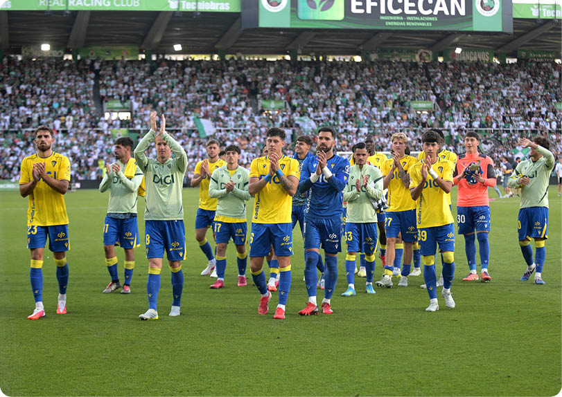 A group of soccer players are standing on a field. Descripci n generada con IA