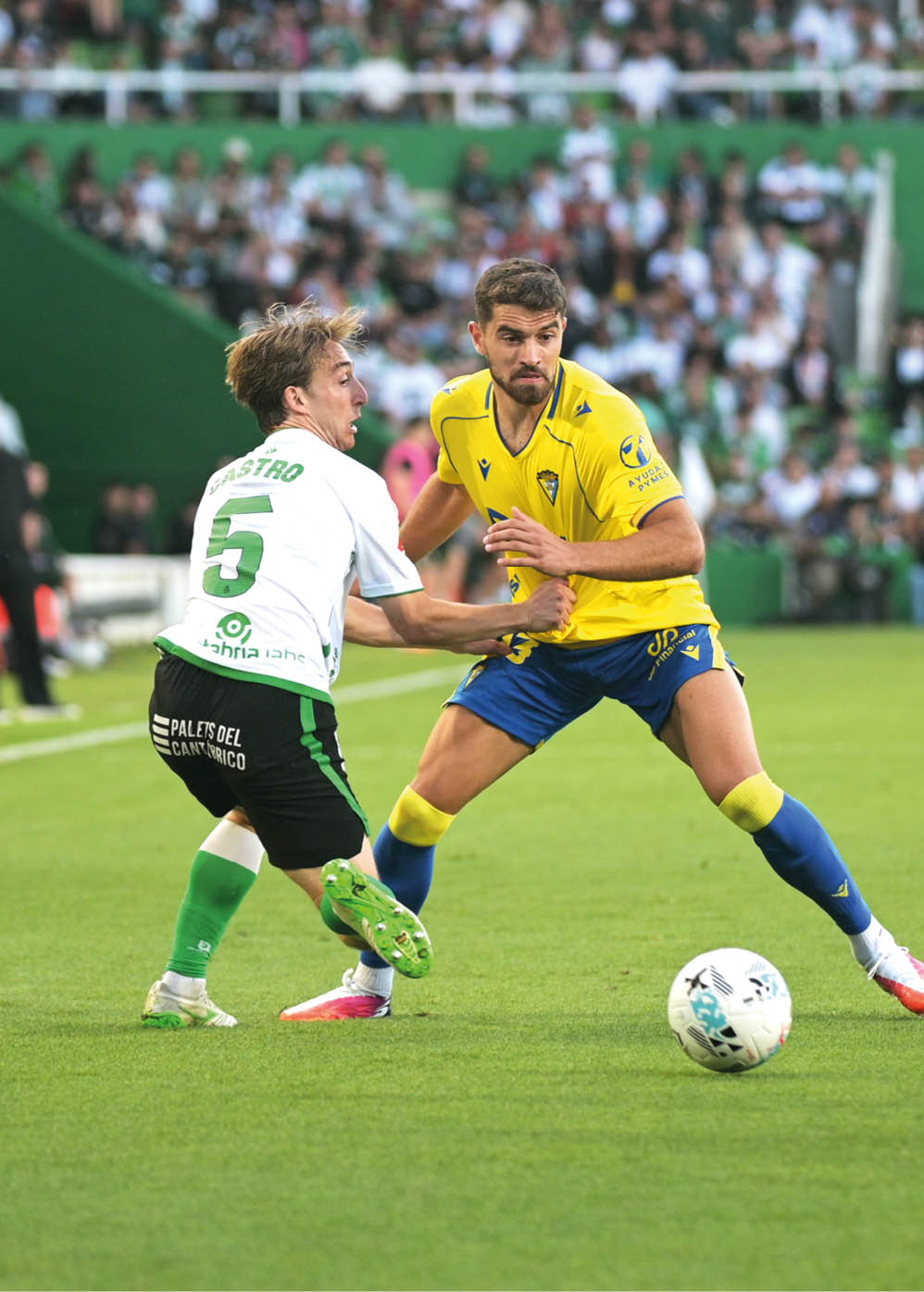 Two soccer players on a field. Descripci n generada con IA