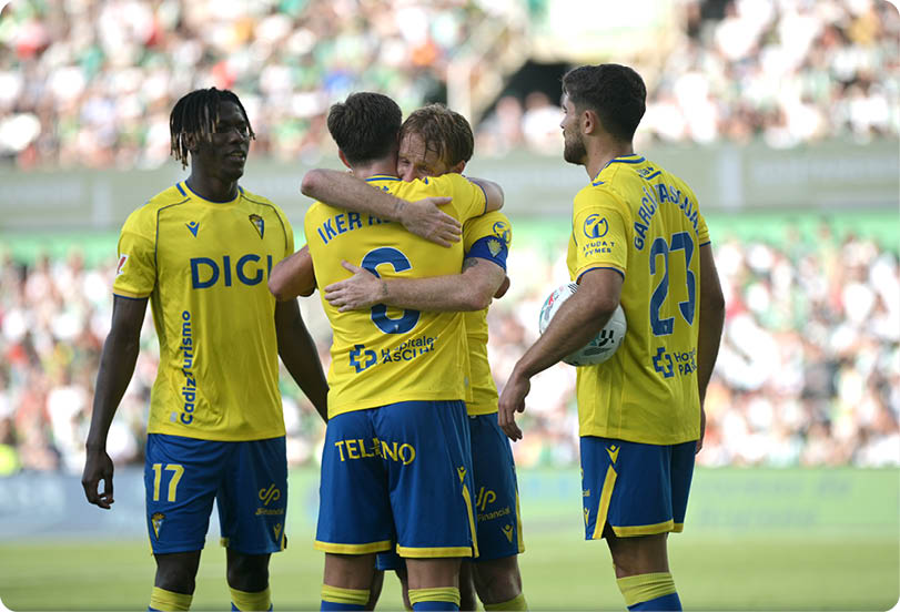 A group of men wearing yellow shirts and blue shorts. Descripci n generada con IA