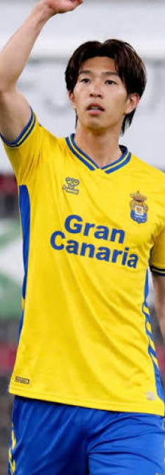 Persona con camiseta amarilla y pantalones azules de un equipo de f tbol con el texto Gran Canaria saludando o se alando hacia arriba. Descripci n generada con IA