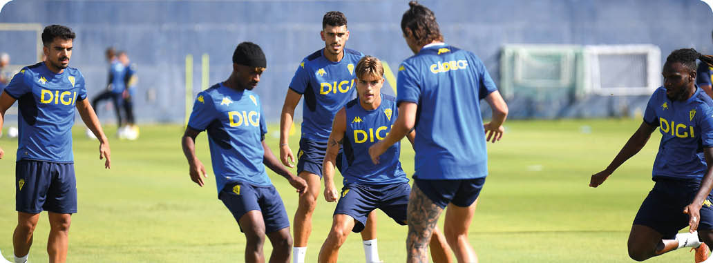Personas con camisetas azules con el logo DIGI entrenan en un campo de f tbol al aire libre. Descripci n generada con IA