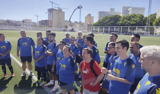 Un grupo de personas vestidas con uniformes deportivos azules est n reunidas en un campo de f tbol al aire libre durante el d a. Descripci n generada con IA