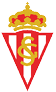 Escudo triangular con franjas verticales rojas y blancas coronado por una corona dorada y con las letras entrelazadas S y G en dorado en el centro. Descripci n generada con IA