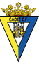 Escudo del C diz C.F. con una corona dorada en la parte superior, un fondo dividido en amarillo y azul con el texto CADIZ C.F. y una figura humana entre dos leones frente a dos columnas con las palabras FLVIA y VLTLA. Descripci n generada con IA